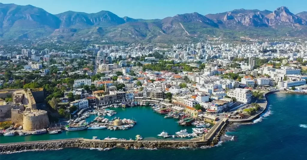 Aerial view of Kyrenia city and harbor in North Cyprus with boats, historic castle, mountains, and coastline — a popular study destination for international students.