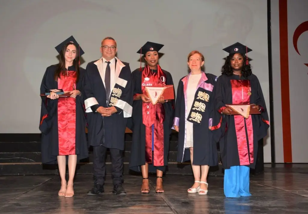 International students graduating at Near East University (NEU) in North Cyprus, wearing academic gowns and receiving diplomas during the graduation ceremony.