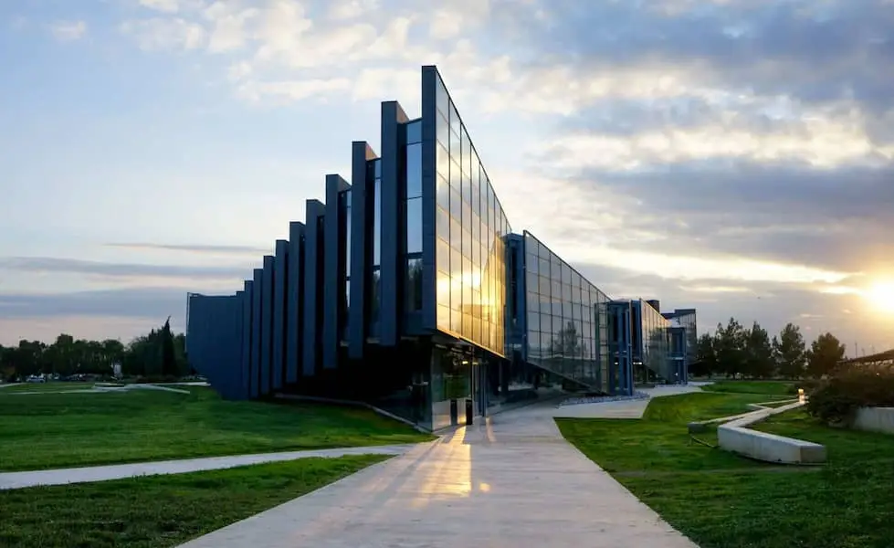 Modern glass building of the Faculty of Science and Technology at Cyprus International University (CIU) in North Cyprus during sunset.