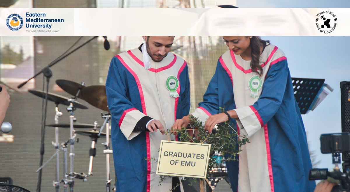 Male and female graduates in academic gowns at Eastern Mediterranean University (EMU) in North Cyprus participating in the graduation ceremony planting ritual.
