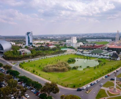 Panoramic aerial view of Near East University campus in North Cyprus showing the grand mosque, science building, amphitheater, green spaces, and academic facilities.
