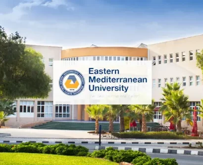 The modern main building and beautiful green campus of Eastern Mediterranean University (EMU) in Famagusta, North Cyprus, under a clear blue sky.