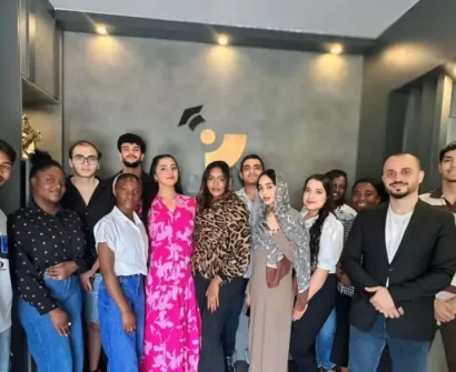 Group of international students from Africa, the Middle East, and Asia standing together in an educational office in North Cyprus, representing multicultural student life.